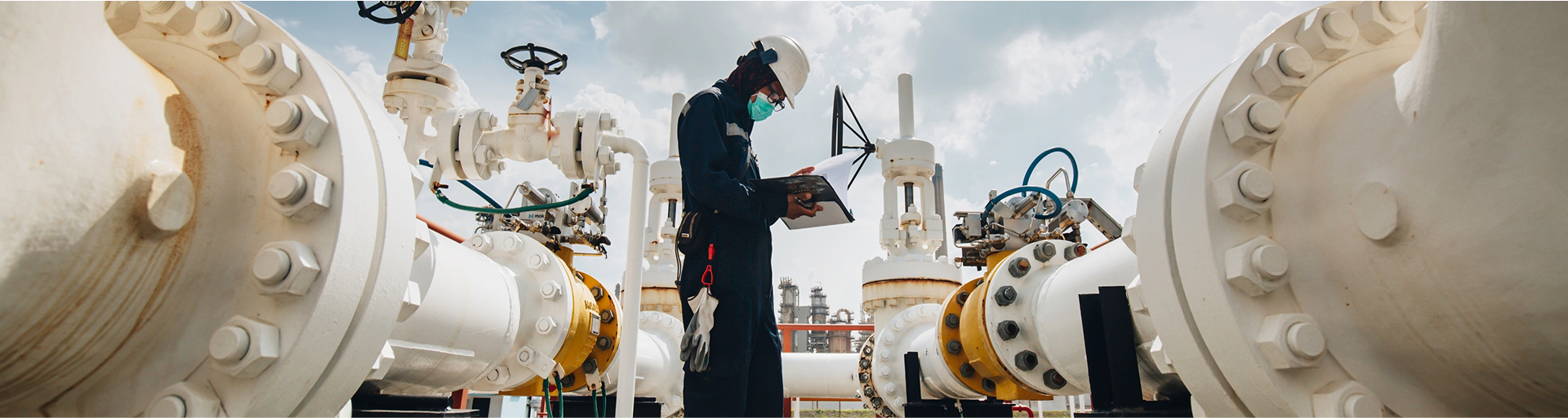 Engineer reviews files while standing at an industrial site