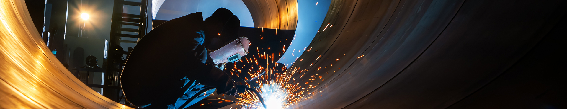 A person welding a large metal structure.