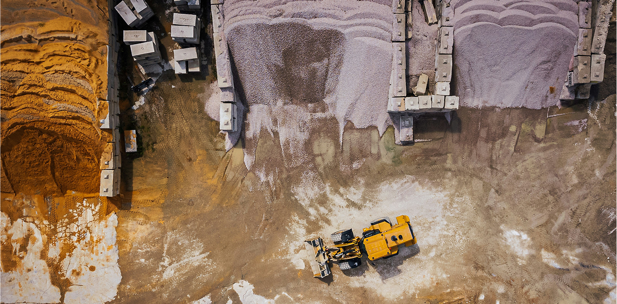 Heavy machinery and materials on site at a cement manufacturing facility.